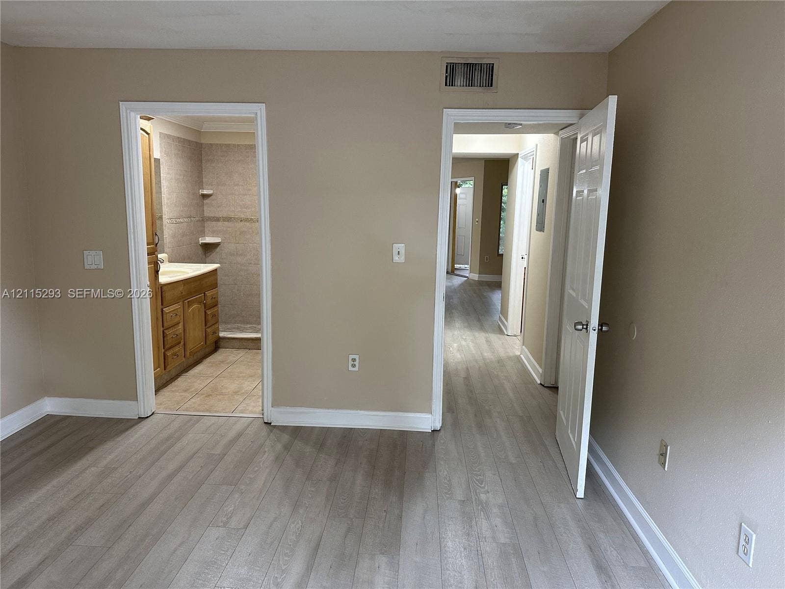 2642 NW 33rd Street, #1902, Oakland Park, Oakland Park, FL 33309 Wood-finish flooring, multi-panel interior doors, and a bathroom featuring wood-toned cabinetry and neutral wall-mounted shelving