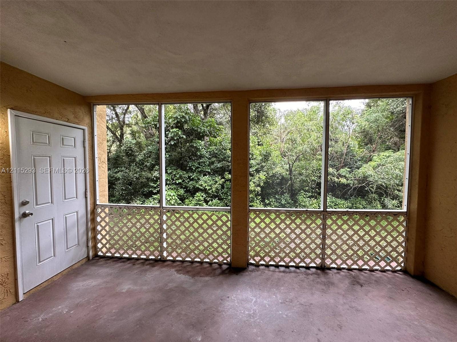 2642 NW 33rd Street, #1902, Oakland Park, Oakland Park, FL 33309 Enclosed porch featuring floor-to-ceiling screens, decorative lattice accents, and a solid-core six-panel door