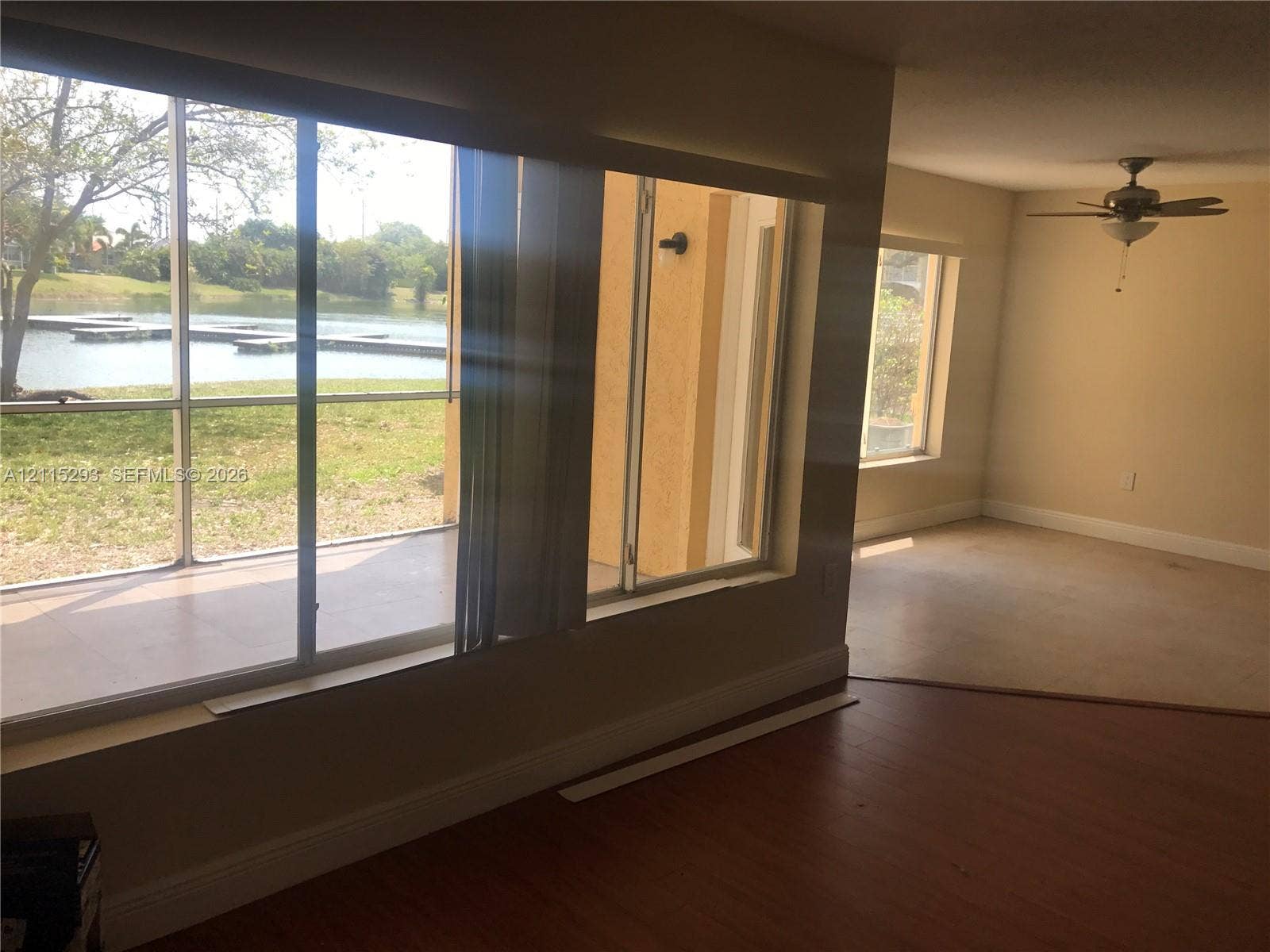 2642 NW 33rd Street, #1902, Oakland Park, Oakland Park, FL 33309 Screened-in patio with waterfront exposure, sliding glass doors, wood-finish flooring, and ceiling fan with integrated lighting
