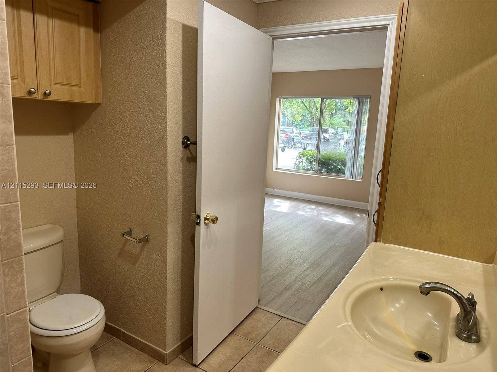 2642 NW 33rd Street, #1902, Oakland Park, Oakland Park, FL 33309 Bathroom featuring tile flooring, a built-in vanity cabinet, a molded countertop with an integrated sink, and an overhead storage cabinet