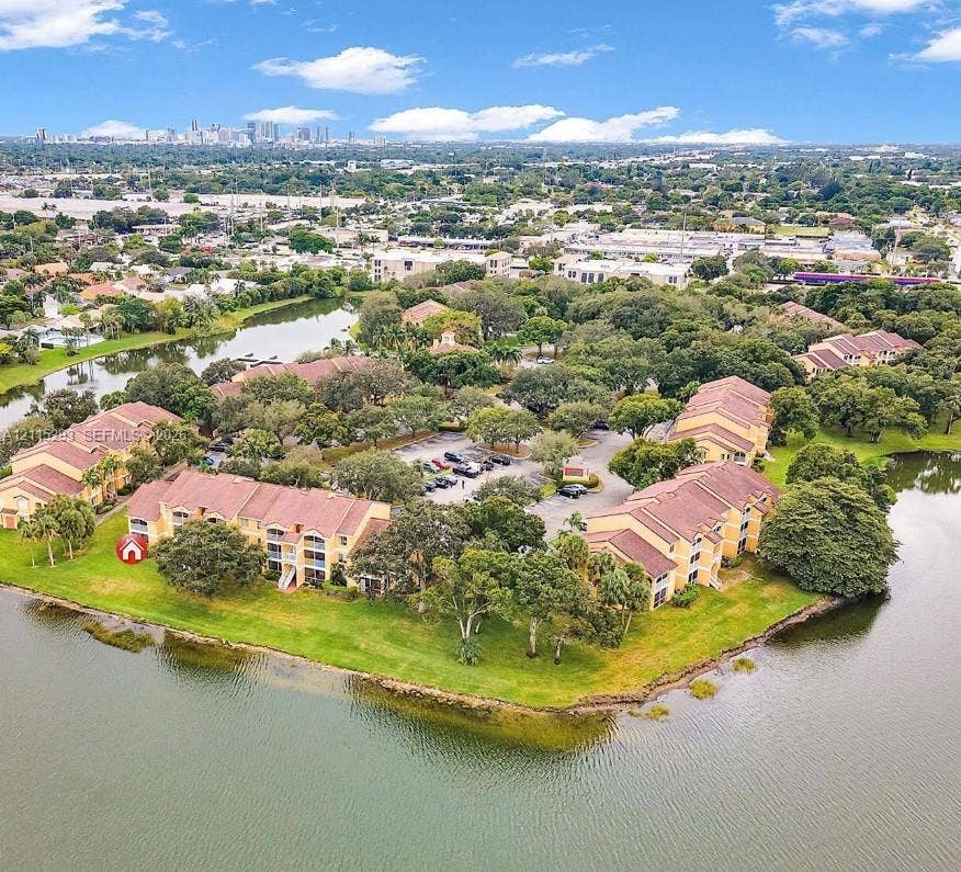 2642 NW 33rd Street, #1902, Oakland Park, Oakland Park, FL 33309 Multi-story residential complex featuring barrel-tile roofs, exterior balconies, expansive waterfront positioning, mature landscaping, and central surface parking