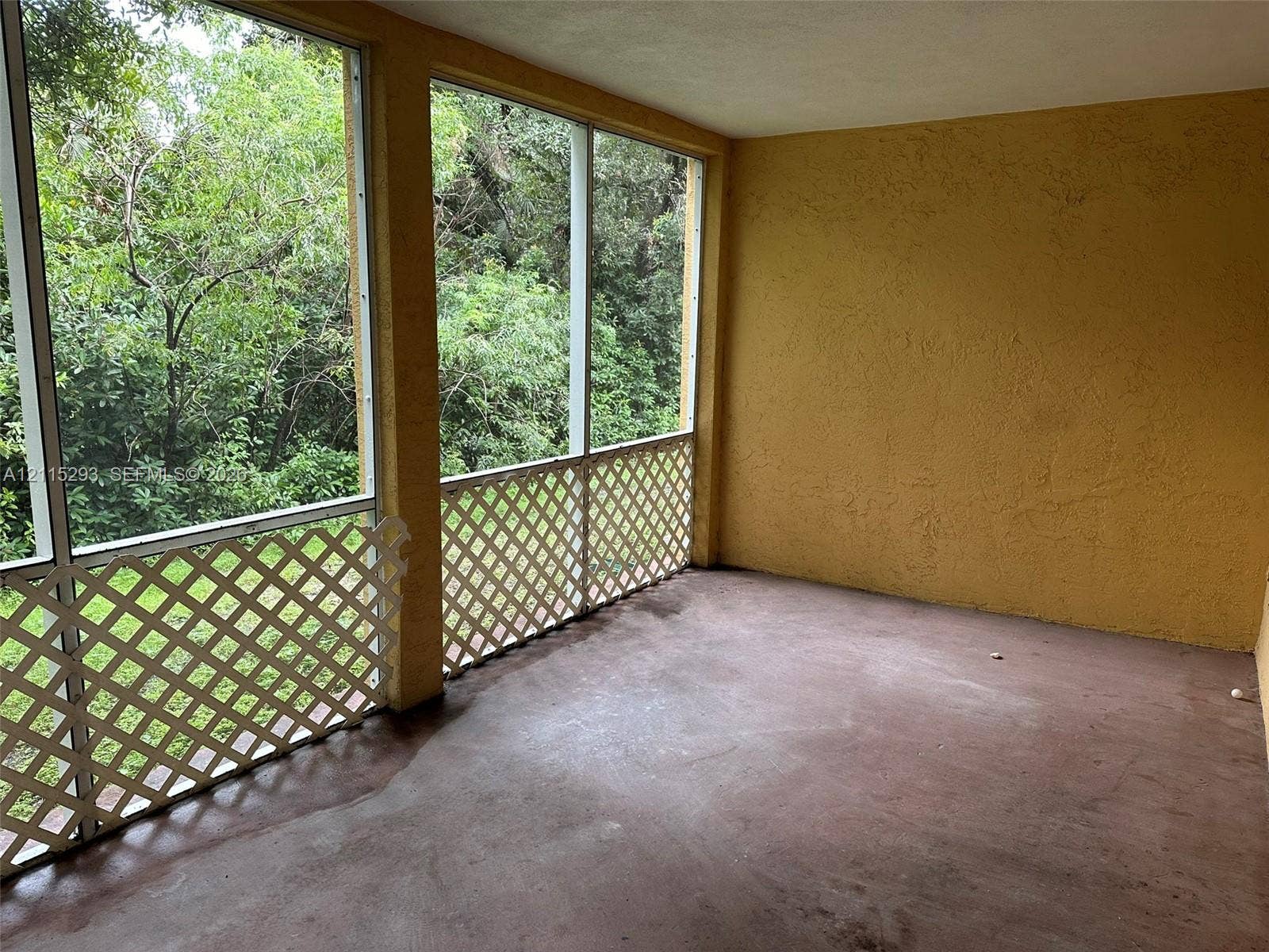 2642 NW 33rd Street, #1902, Oakland Park, Oakland Park, FL 33309 Screened-in porch featuring textured walls, concrete flooring, and white lattice paneling