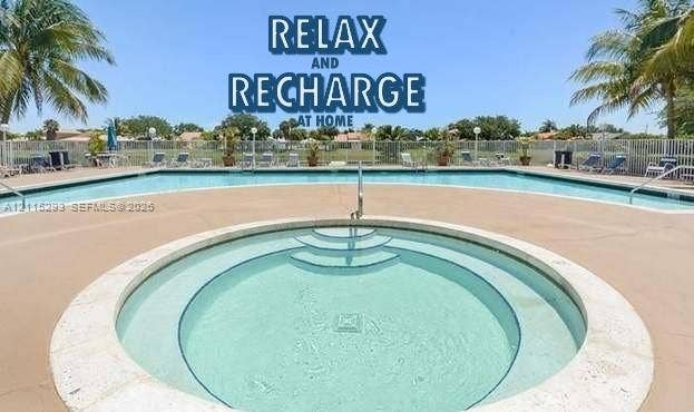 2642 NW 33rd Street, #1902, Oakland Park, Oakland Park, FL 33309 In-ground swimming pool and circular spa featuring concrete decking, metal perimeter fencing, and integrated stairs