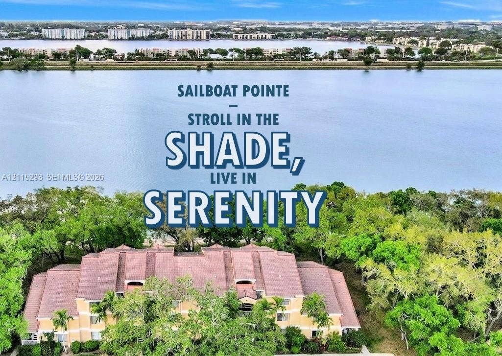 2642 NW 33rd Street, #1902, Oakland Park, Oakland Park, FL 33309 Aerial perspective of a multi-story residential building featuring a multi-gabled roof, light-toned exterior facade, and mature perimeter landscaping, situated directly along the shoreline of a large lake