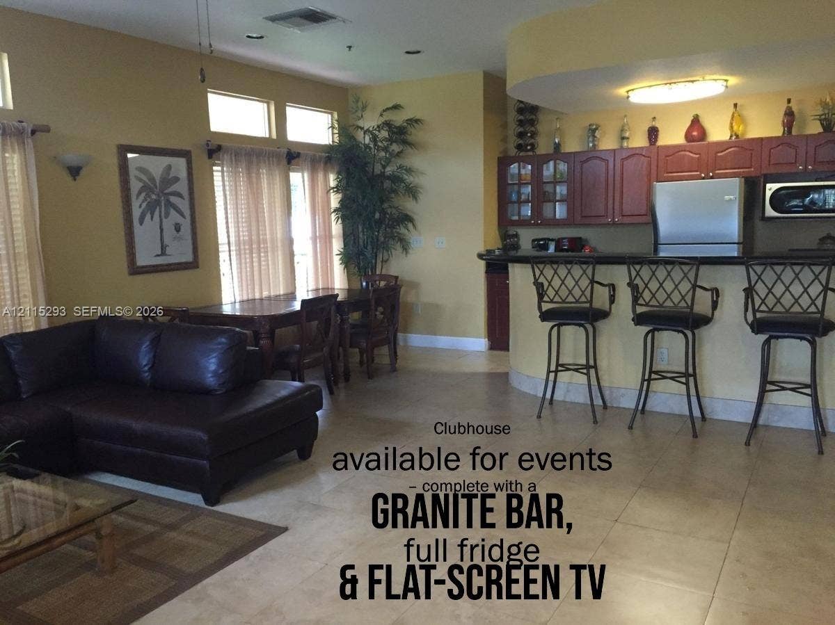 2642 NW 33rd Street, #1902, Oakland Park, Oakland Park, FL 33309 Common area featuring stone-surfaced bar with stainless steel refrigerator, built-in cabinetry, and tile flooring