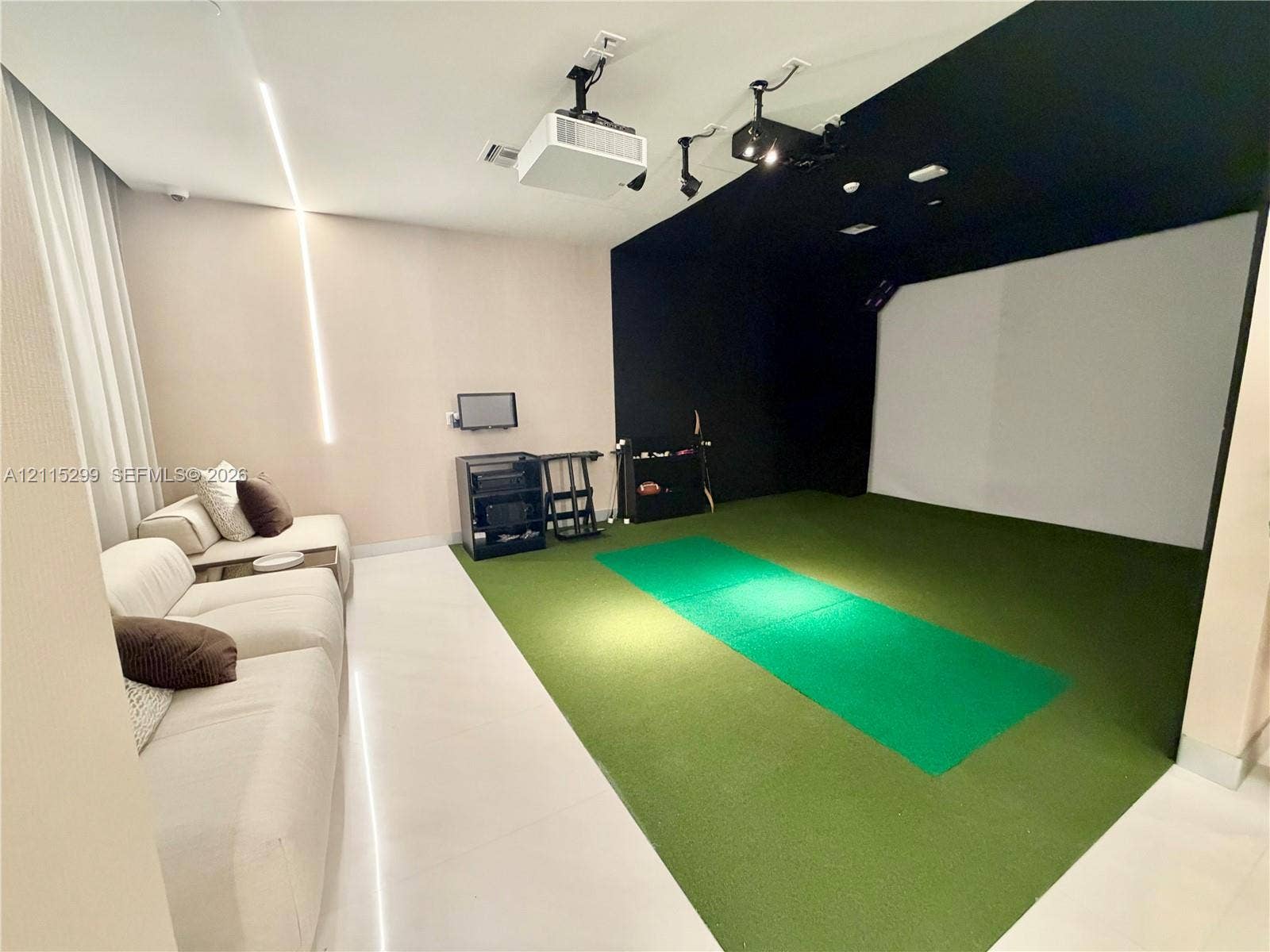 Interior space featuring a golf simulator, ceiling-mounted projector, wall-to-wall carpeting, recessed ceiling lighting, and integrated linear wall lighting