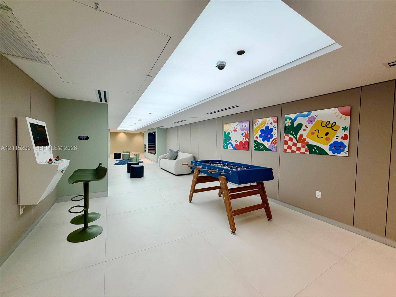 Large-format tile flooring, recessed linear lighting, and wall-mounted multimedia console