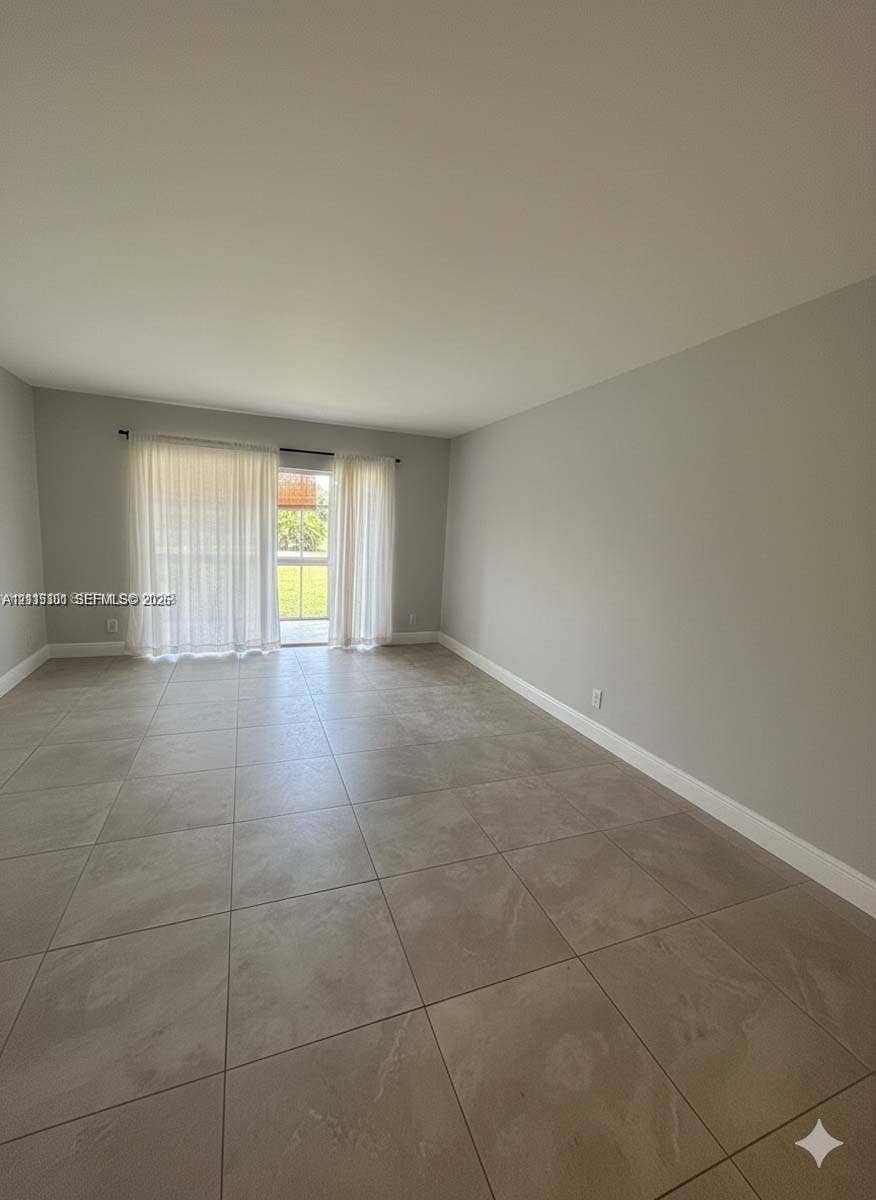 1630 Embassy Drive, #101, West Palm Beach, West Palm Beach, FL 33401 Neutral interior featuring large-format ceramic tile flooring, neutral wall paint, and sliding glass doors