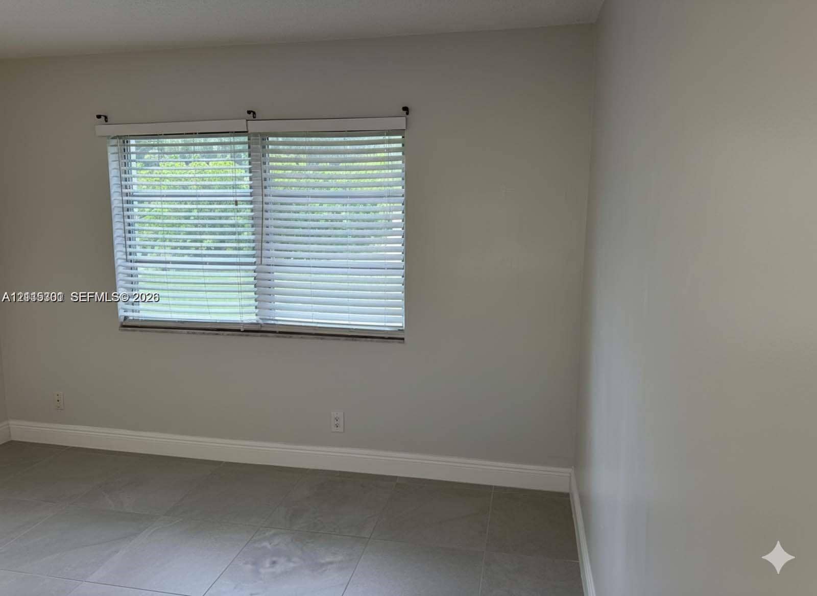 1630 Embassy Drive, #101, West Palm Beach, West Palm Beach, FL 33401 Neutral wall tones, oversized tile flooring, and horizontal window blinds