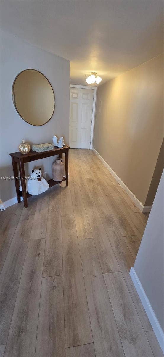 115 Lake Emerald Drive, #408, Oakland Park, FL 33309 Neutral-toned interior featuring wood-finish flooring and a multi-panel door