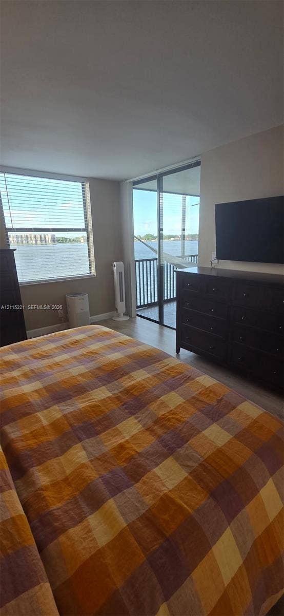 115 Lake Emerald Drive, #408, Oakland Park, FL 33309 Floor-to-ceiling sliding glass doors opening to a balcony, water scenery, and neutral wall tones
