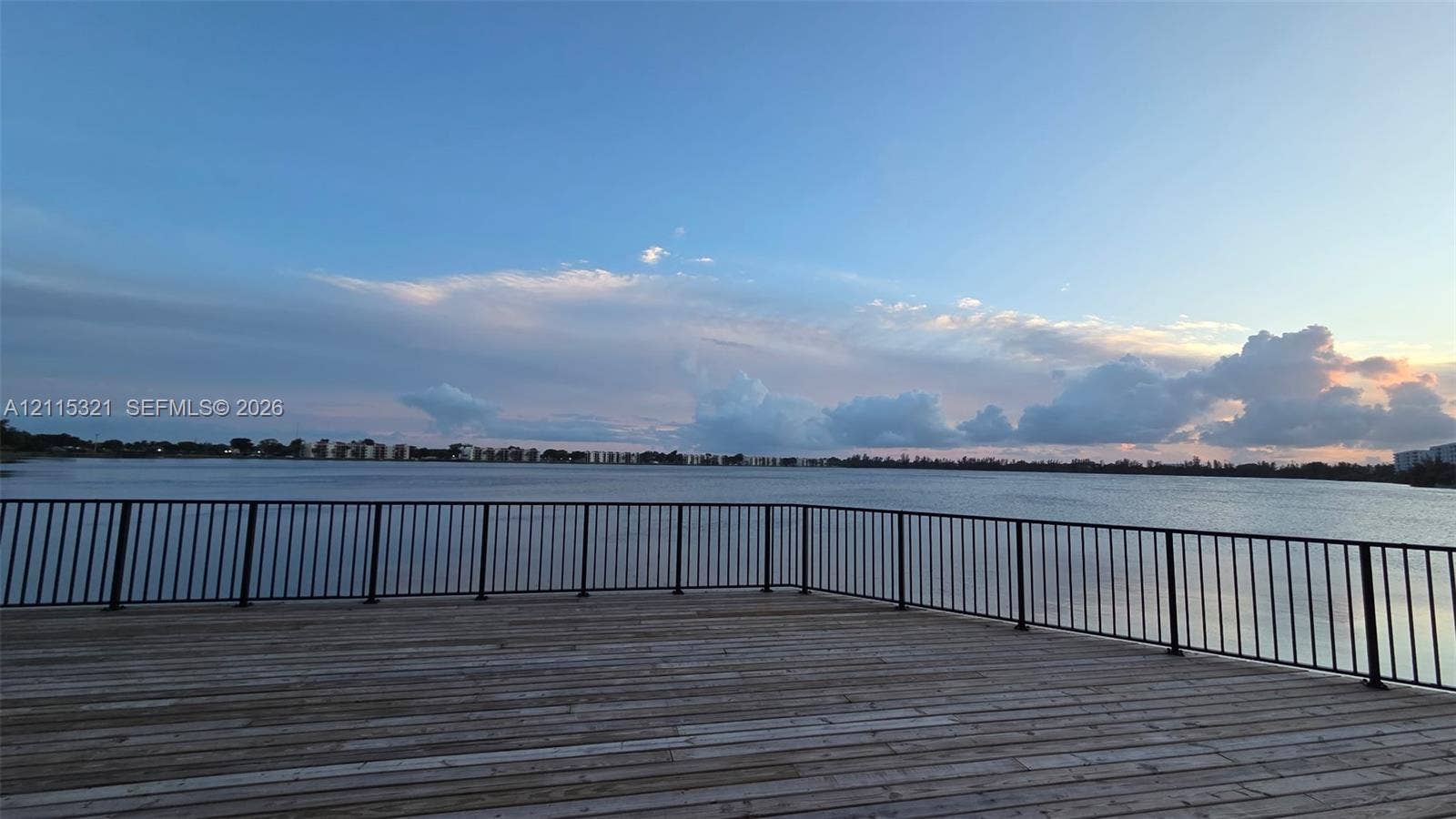 115 Lake Emerald Drive, #408, Oakland Park, FL 33309 Wood-plank deck featuring a black metal railing overlooking the water
