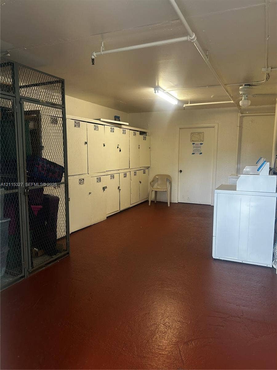 335 Brighton H, #H, Boca Raton, Boca Raton, FL 33434 Utility room featuring metal storage lockers, a secure wire mesh enclosure, painted concrete flooring, and an integrated fire sprinkler system