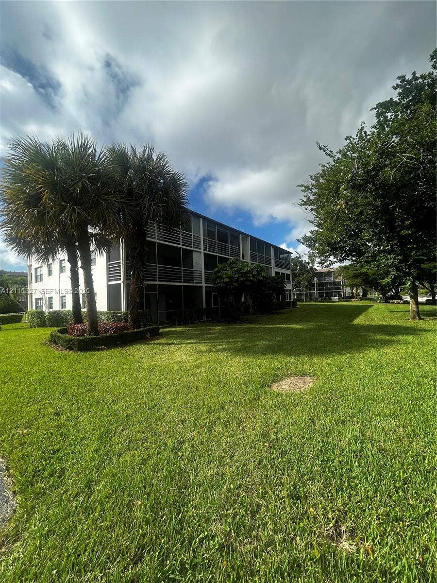 335 Brighton H, #H, Boca Raton, Boca Raton, FL 33434 Multi-story exterior with screened balconies, expansive lawn, and mature landscaping