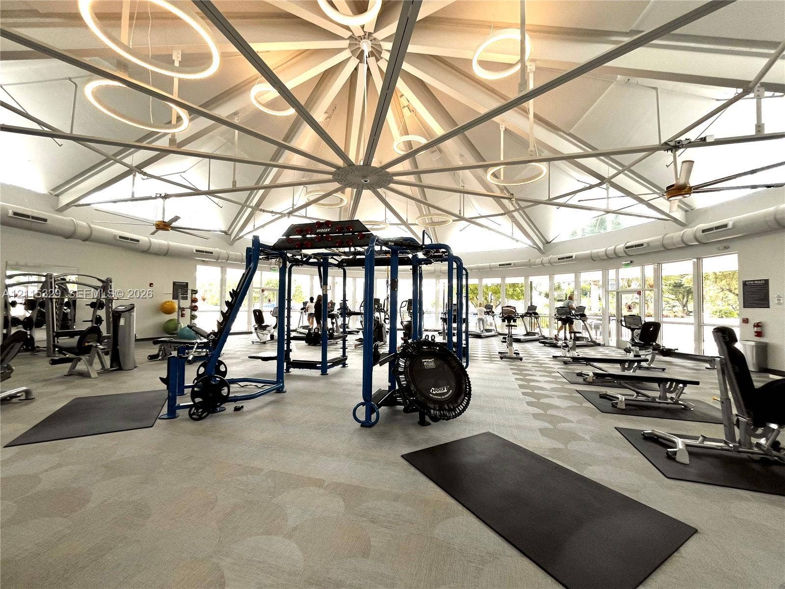 2500 Parkview Drive, #1705, Hallandale Beach, Hallandale Beach, FL 33009 Vaulted radial ceiling featuring exposed structural beams, circular pendant lighting, full-perimeter floor-to-ceiling windows, and patterned flooring