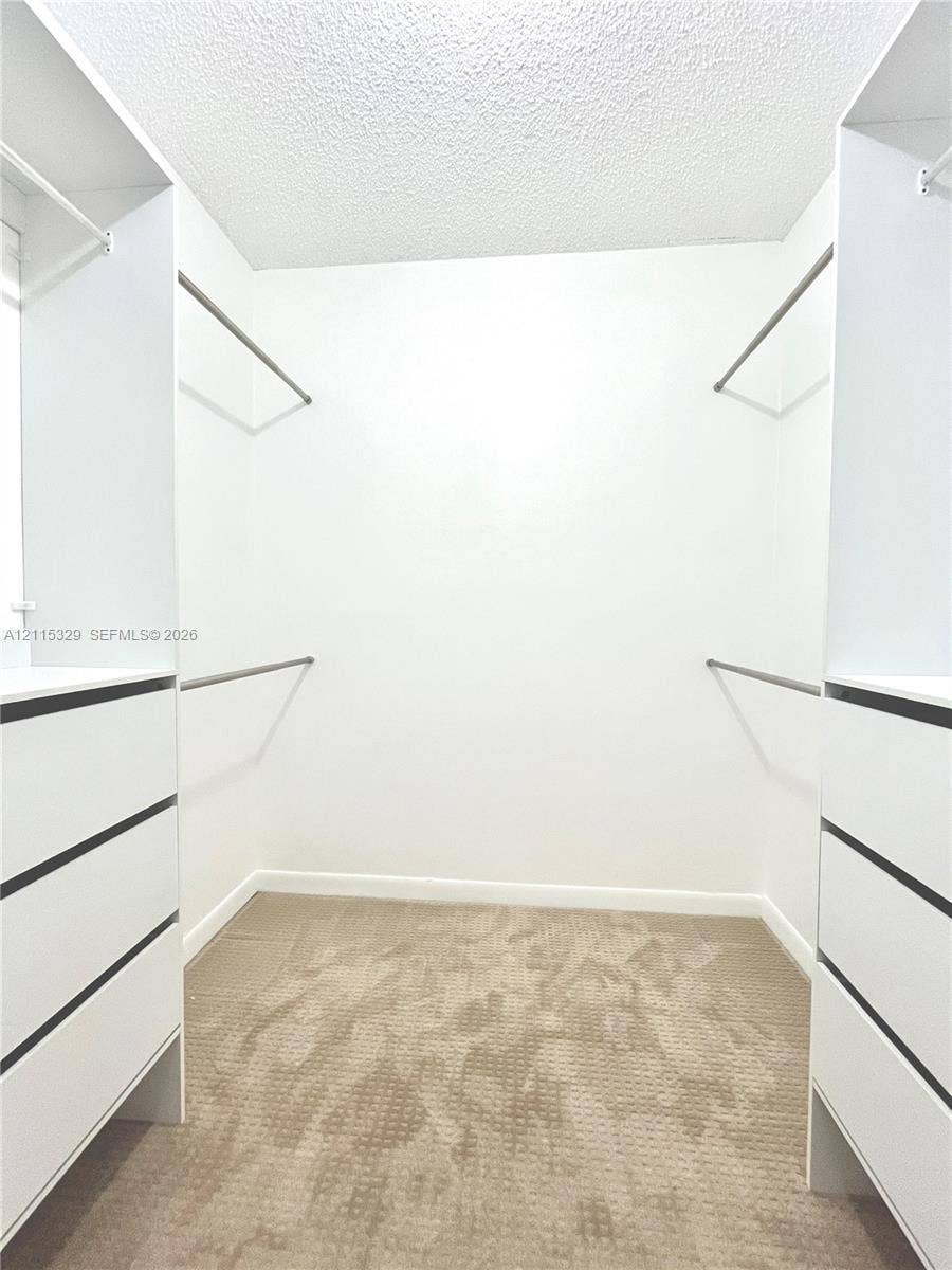 2500 Parkview Drive, #1705, Hallandale Beach, Hallandale Beach, FL 33009 Walk-in closet featuring white built-in cabinetry, multiple drawers, tiered clothing rods