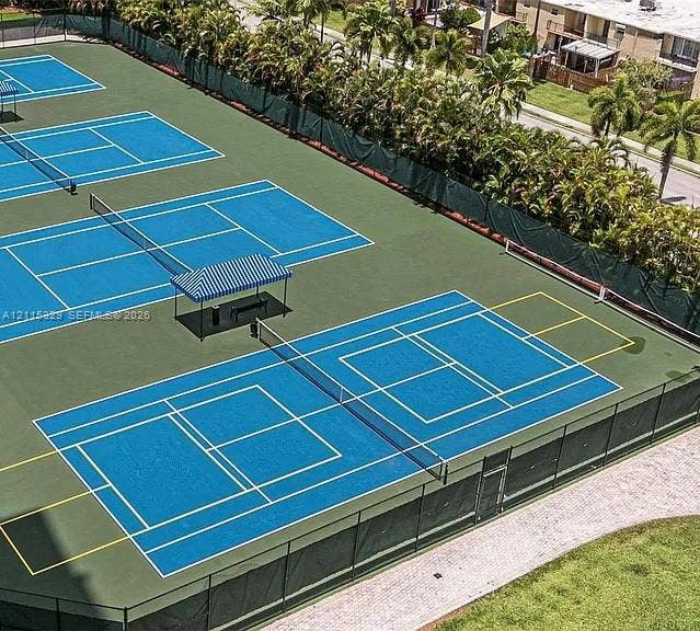 2500 Parkview Drive, #1705, Hallandale Beach, Hallandale Beach, FL 33009 Multiple tennis courts featuring blue playing surfaces, perimeter fencing, and shaded bench seating