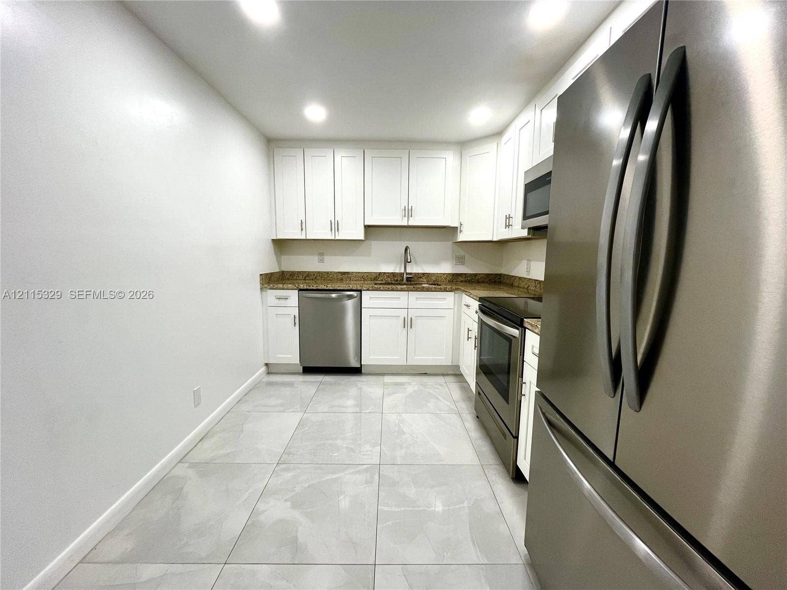 2500 Parkview Drive, #1705, Hallandale Beach, Hallandale Beach, FL 33009 Kitchen featuring white cabinetry, stone-finish countertops, stainless steel appliances, and large-format tile flooring