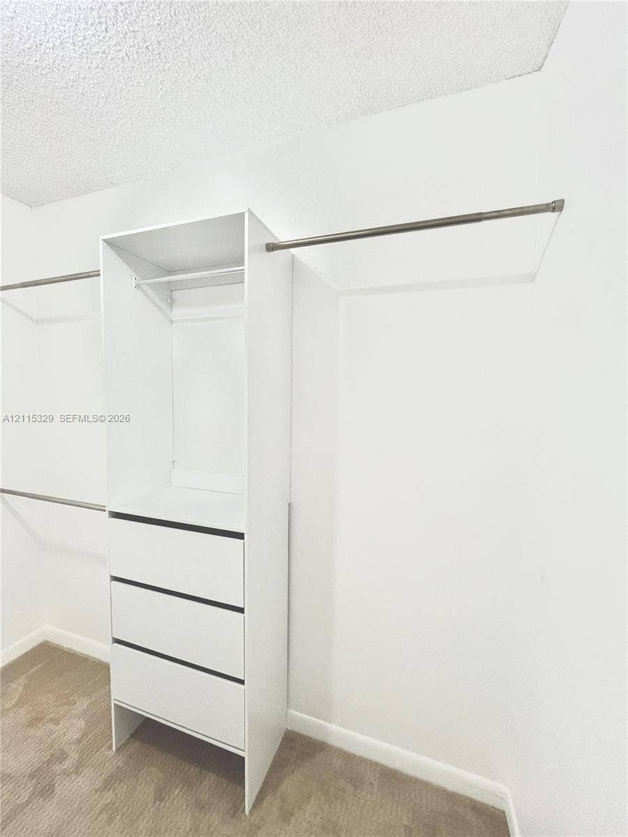 2500 Parkview Drive, #1705, Hallandale Beach, Hallandale Beach, FL 33009 Walk-in closet featuring white built-in cabinetry, three storage drawers, and dual-level metal hanging rods
