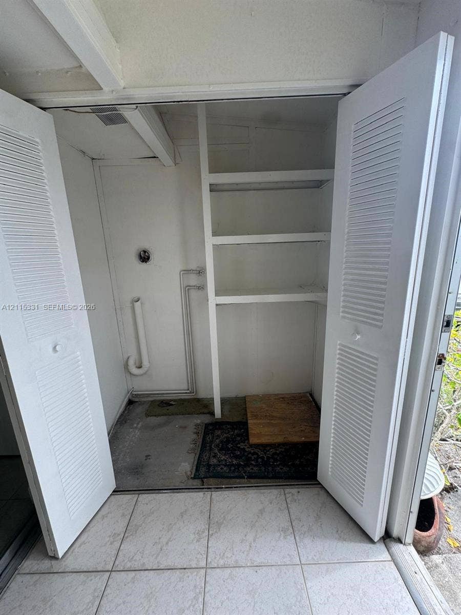22 Valencia A, Delray Beach, FL 33446 Laundry closet with stacked washer and dryer 1 year old