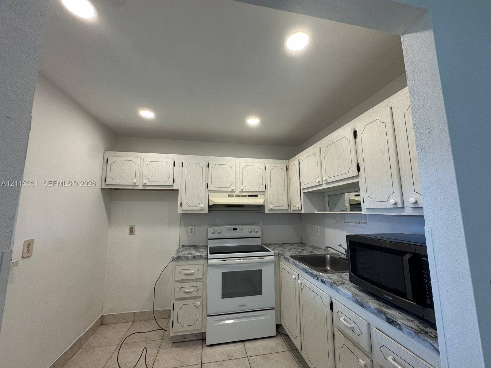 22 Valencia A, Delray Beach, FL 33446 Kitchen featuring white cabinetry, stone-finish countertops, stainless steel sink, recessed lighting, and white electric range
