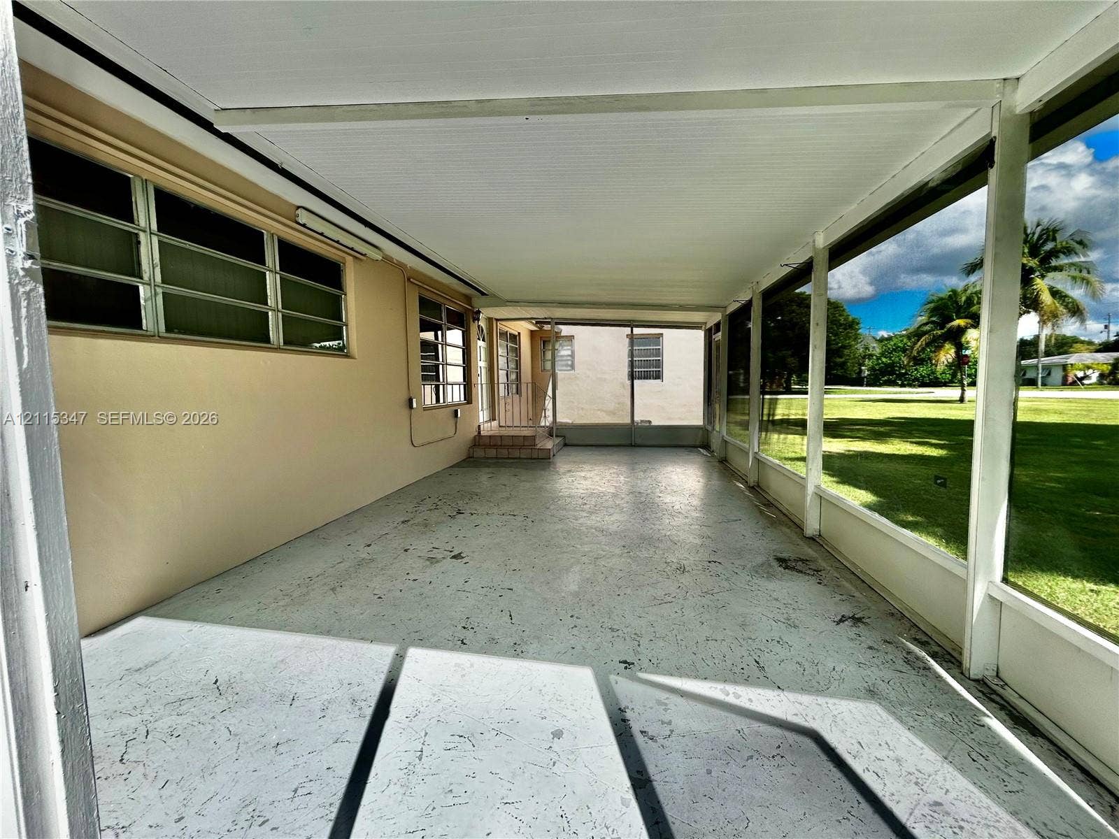 Screened-in patio featuring a concrete floor, solid roof covering, and horizontal sliding windows