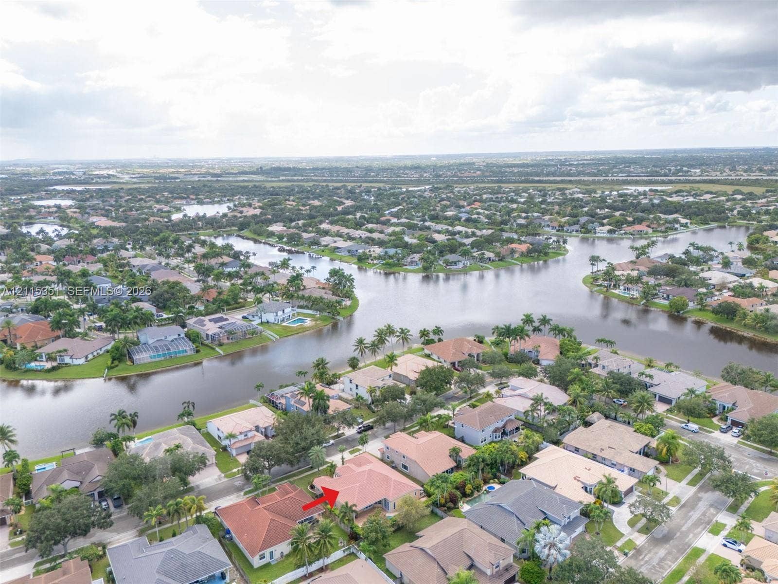 13845 NW 20th Street, Pembroke Pines, FL 33028 Aerial perspective of a residential property featuring a tiled hip roof and a landscaped lot situated on a canal