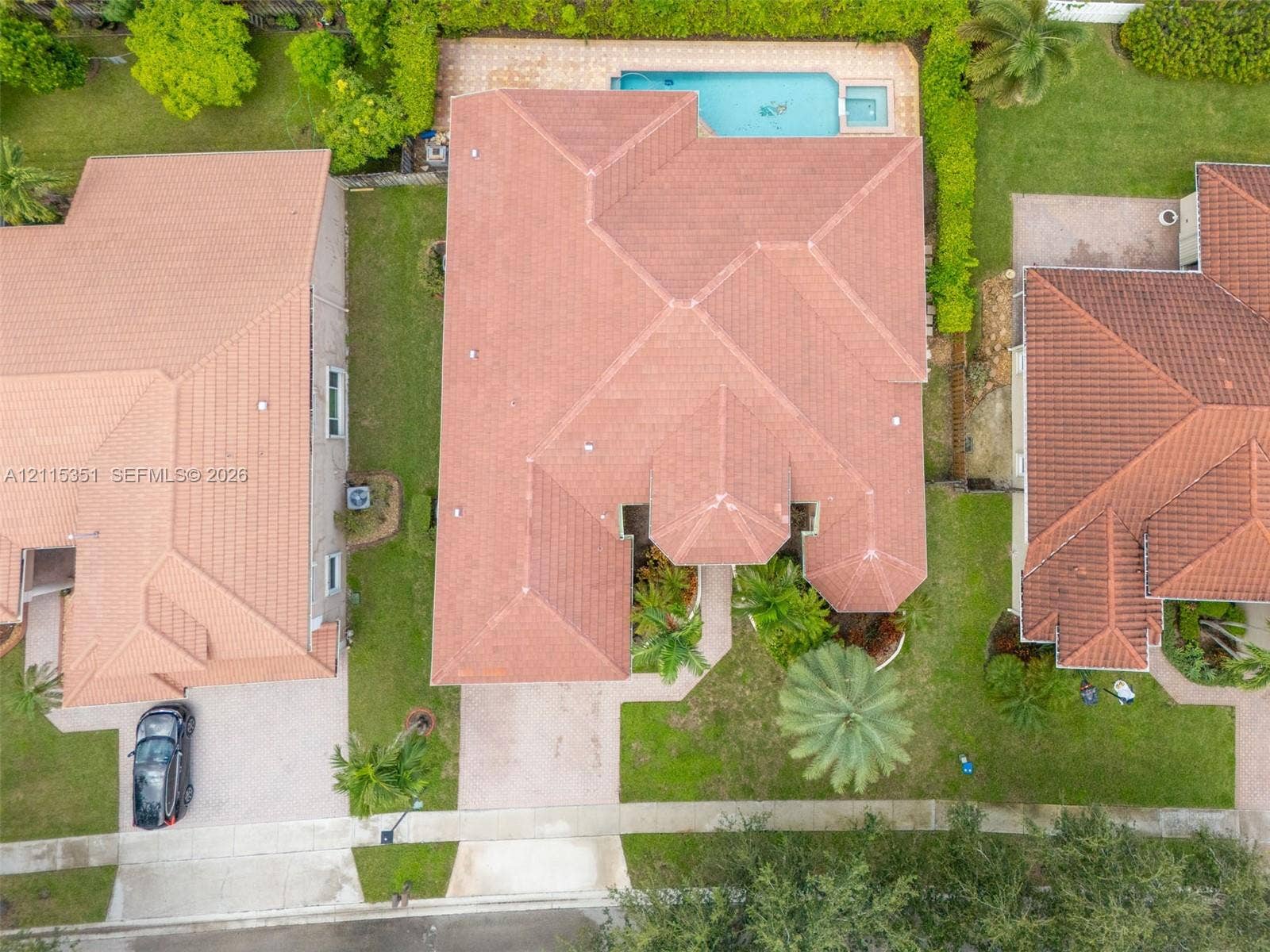 13845 NW 20th Street, Pembroke Pines, FL 33028 Aerial perspective featuring a tile roof, paved driveway, swimming pool with attached spa, and mature landscaping
