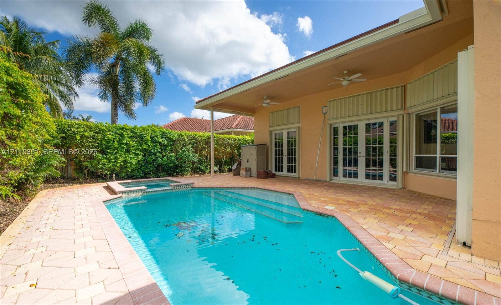 13845 NW 20th Street, Pembroke Pines, FL 33028 In-ground swimming pool with an integrated spa, paver patio, covered lanai, and glass-paned double doors