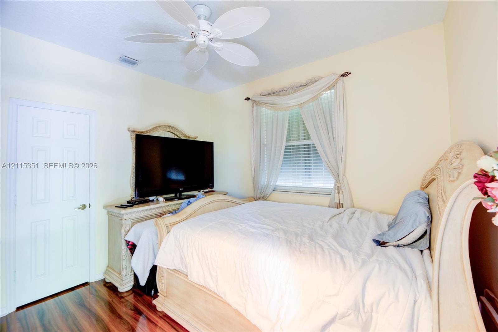 13845 NW 20th Street, Pembroke Pines, FL 33028 Polished wood-finish flooring, ceiling-mounted multi-blade fan, and window featuring horizontal blinds