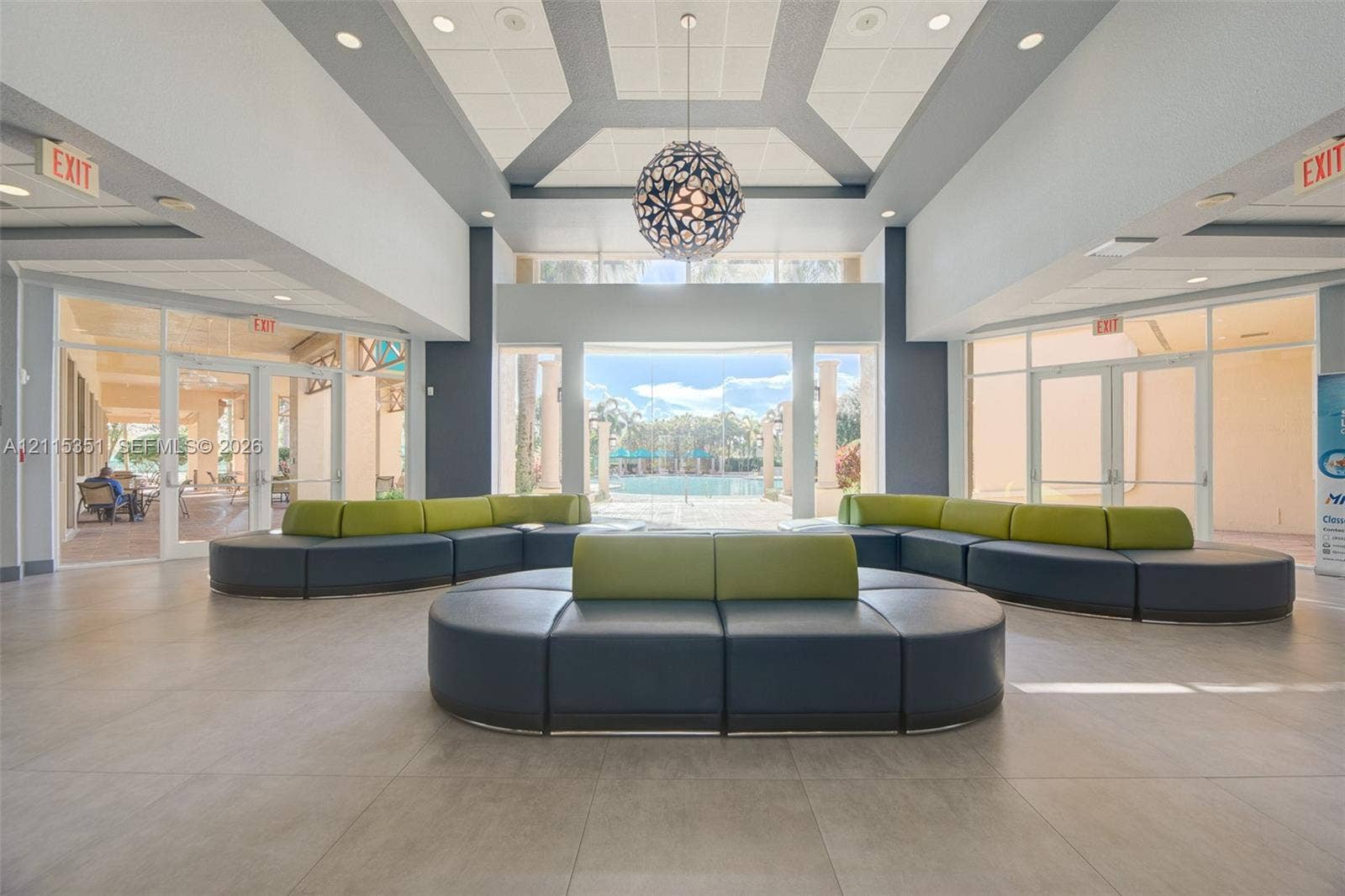 13845 NW 20th Street, Pembroke Pines, FL 33028 Lobby featuring tile flooring, a recessed tray ceiling with accent lighting, a decorative spherical pendant light, and floor-to-ceiling glass wall panels