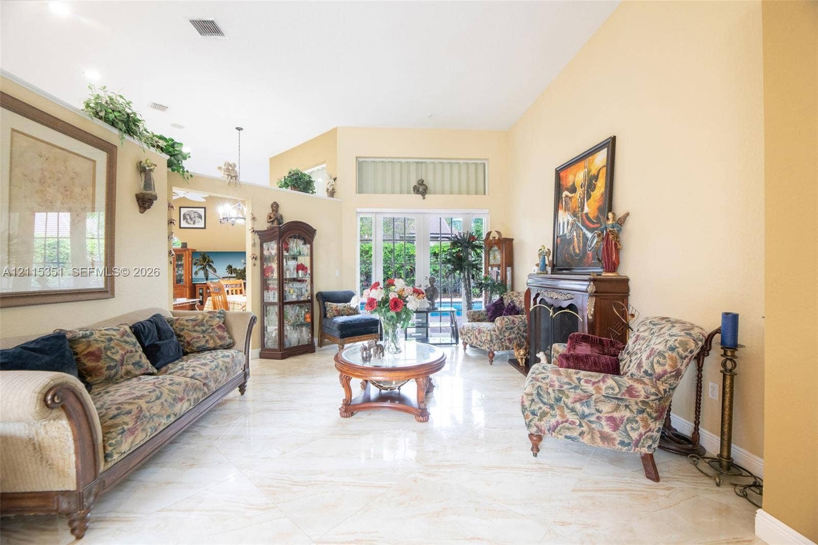 13845 NW 20th Street, Pembroke Pines, FL 33028 Living area featuring vaulted ceilings, polished tile flooring, a built-in fireplace, and expansive glass doors