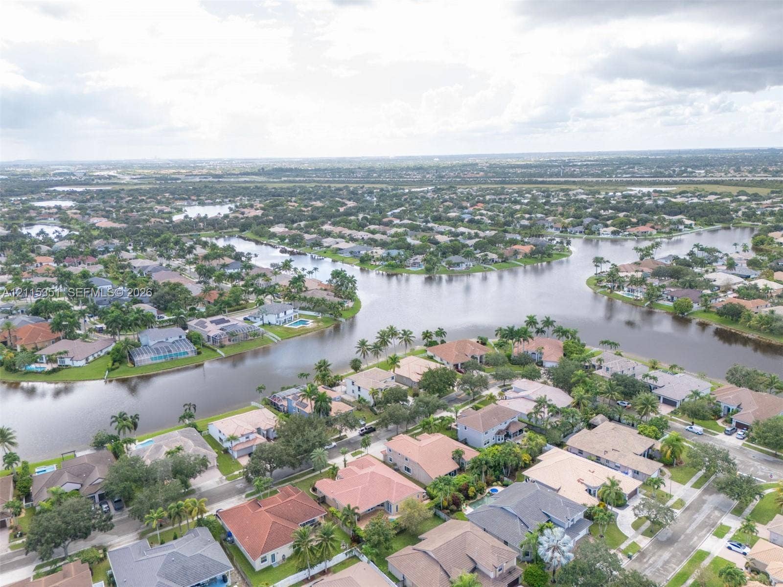 13845 NW 20th Street, Pembroke Pines, FL 33028 Aerial perspective of a waterfront residential community featuring expansive canal systems, tile-roofed housing, and established tropical landscaping