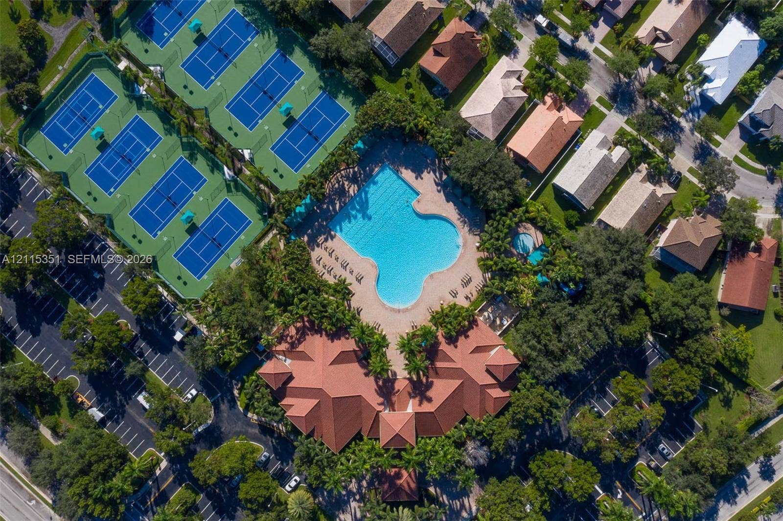 13845 NW 20th Street, Pembroke Pines, FL 33028 Community amenities featuring a large outdoor swimming pool, a secondary circular pool, multiple tennis courts, and a central clubhouse with a terracotta-style tile roof