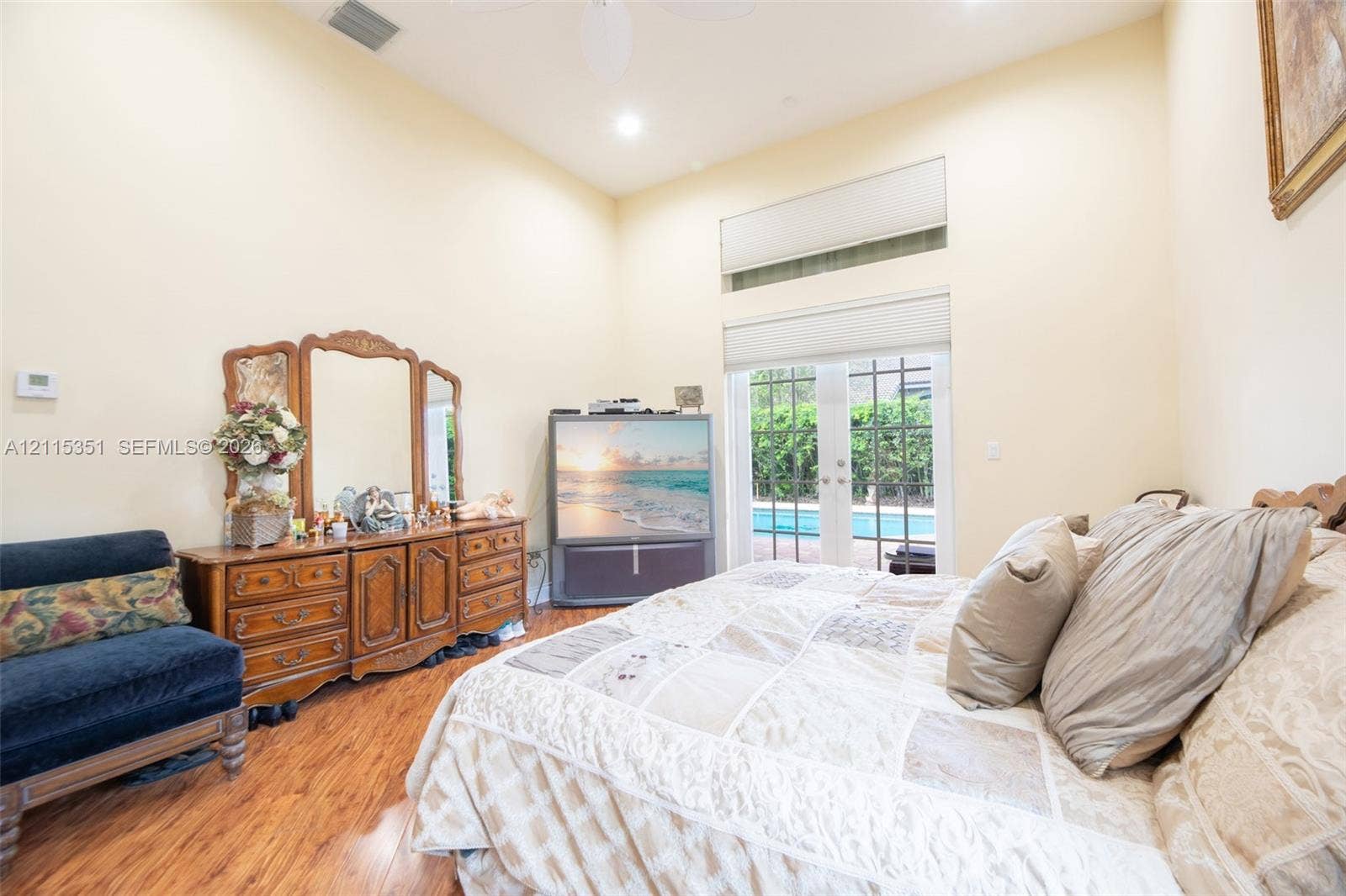 13845 NW 20th Street, Pembroke Pines, FL 33028 Vaulted ceilings, wood-finish flooring, transom window, and glass-paned double doors with outdoor pool access