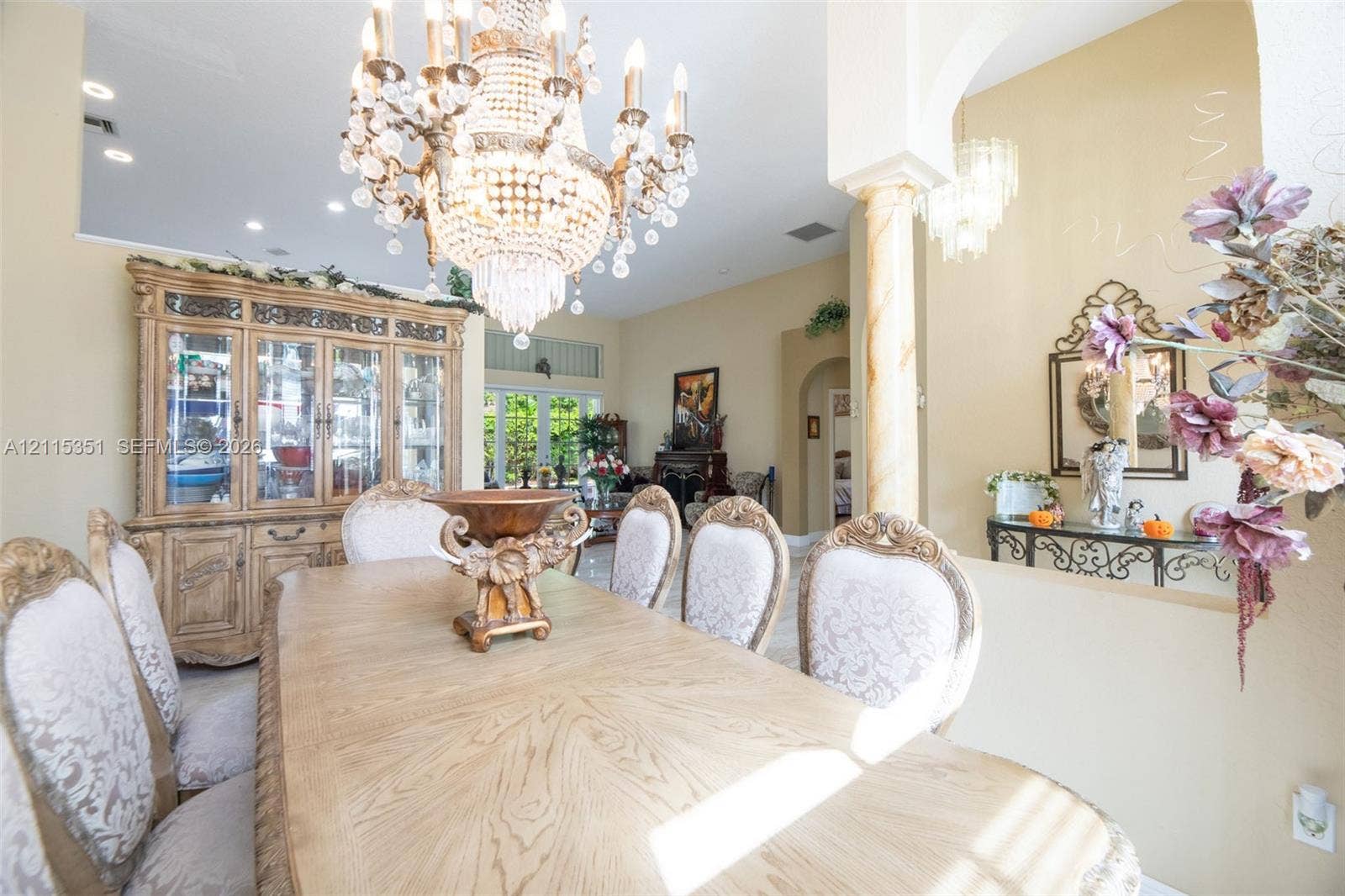 13845 NW 20th Street, Pembroke Pines, FL 33028 Dining area featuring high ceilings, a decorative crystal chandelier, a classic column, and arched entryways