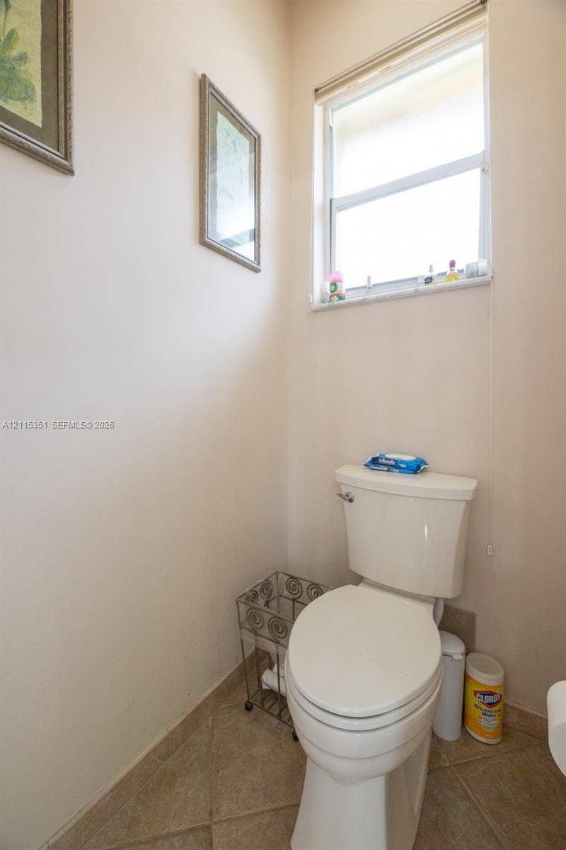 13845 NW 20th Street, Pembroke Pines, FL 33028 Standard-height toilet with a dual-flush tank and a multi-pane window with a neutral tile floor