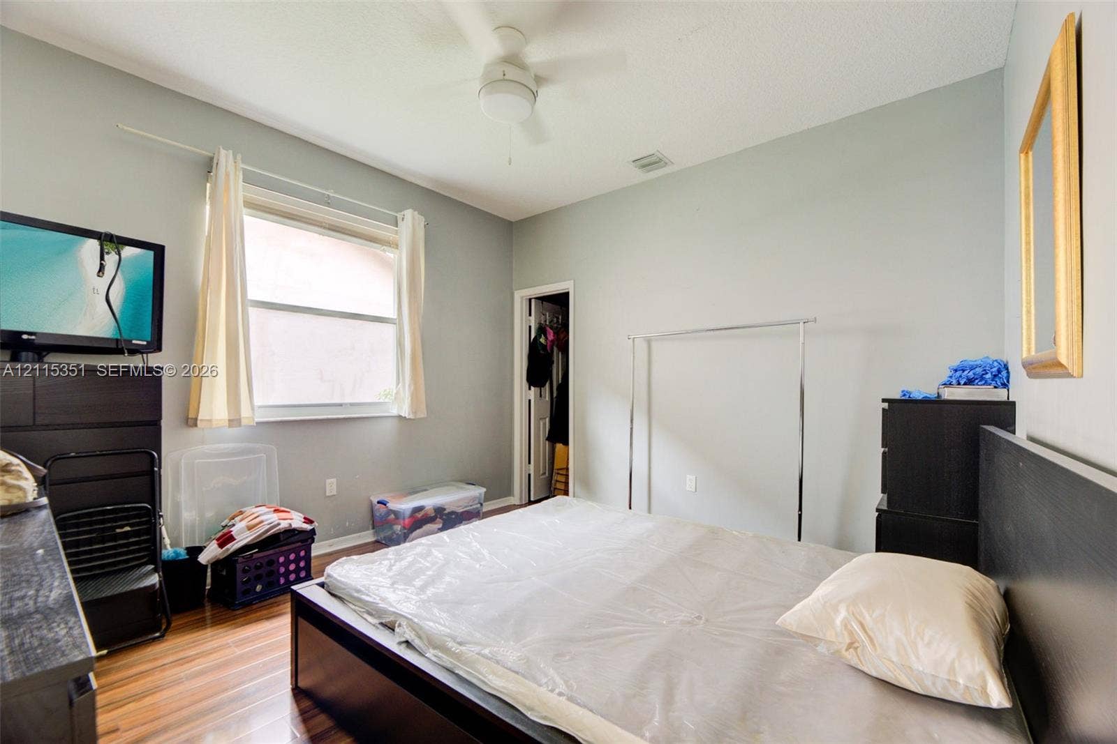 13845 NW 20th Street, Pembroke Pines, FL 33028 Room featuring wood-finish flooring, a ceiling fan with integrated lighting, and a window with horizontal blinds