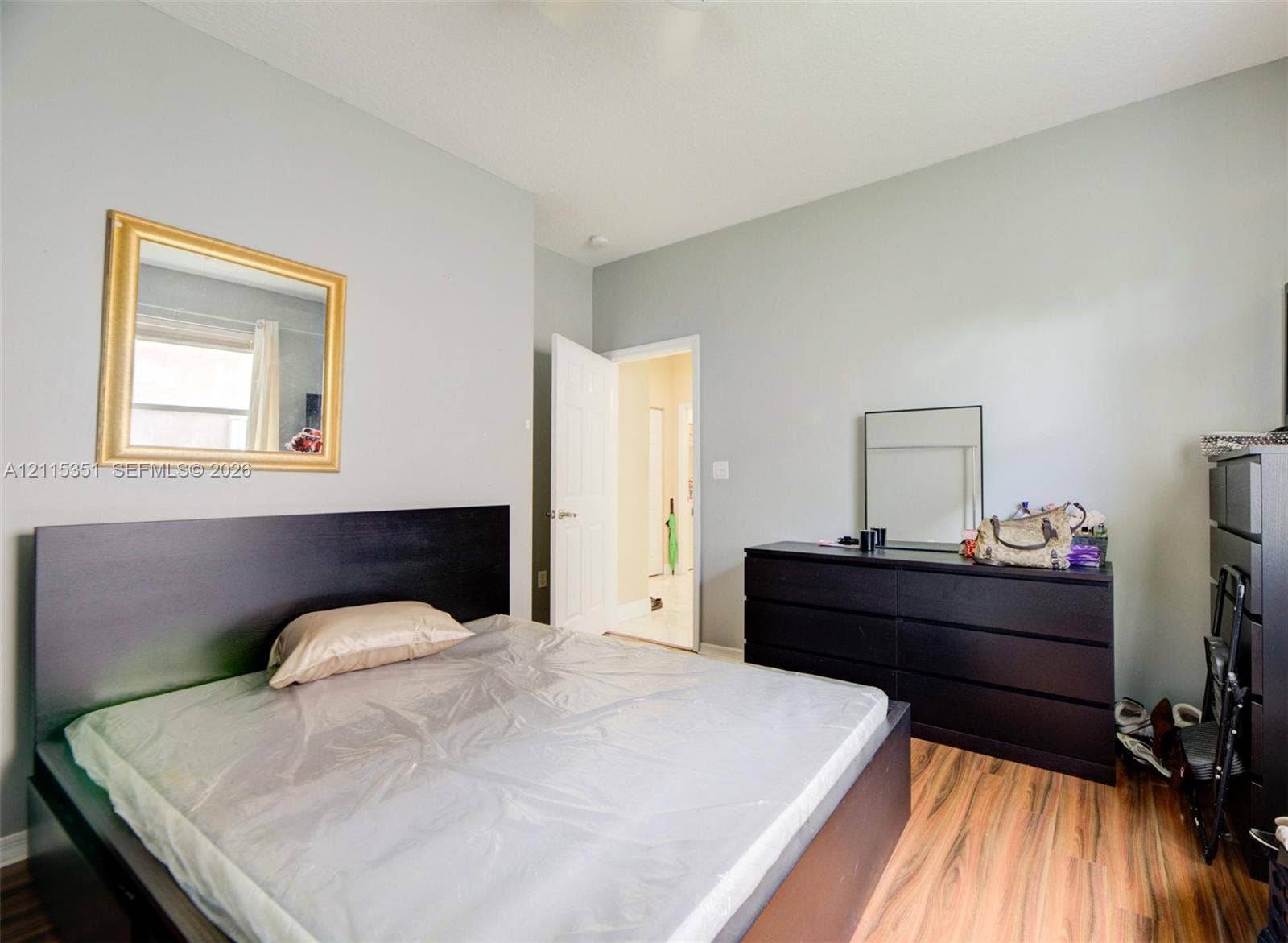 13845 NW 20th Street, Pembroke Pines, FL 33028 Neutral-toned interior walls featuring wood-finish flooring and a single-panel interior door