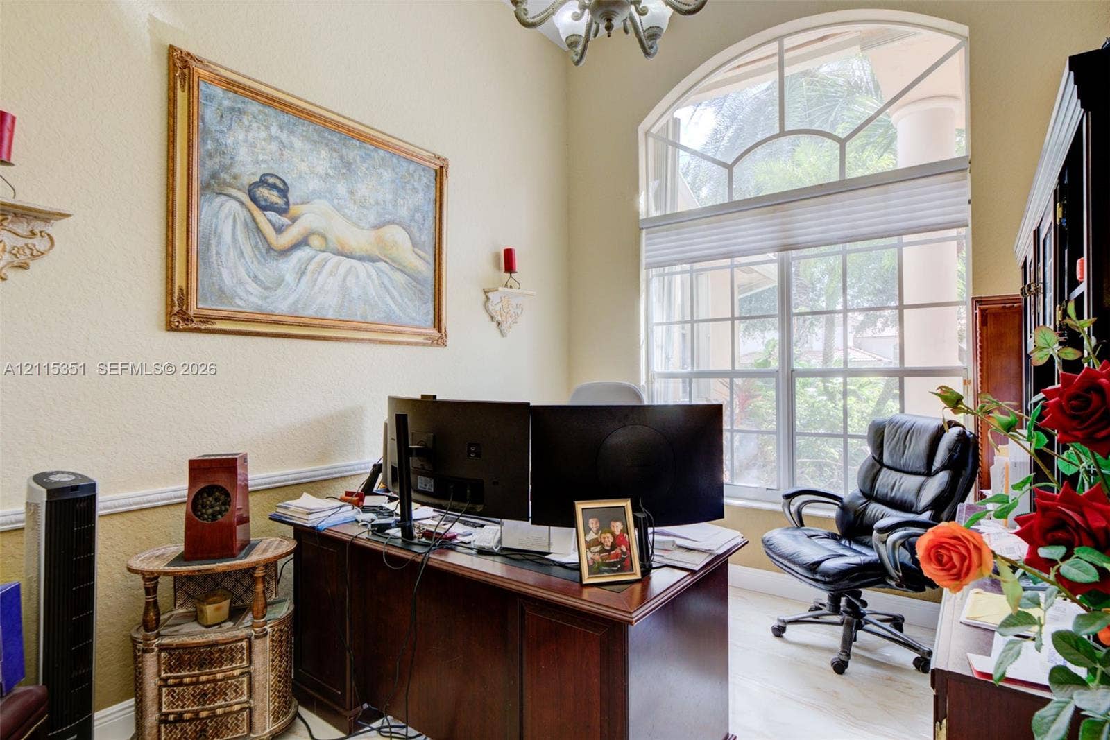 13845 NW 20th Street, Pembroke Pines, FL 33028 High-ceiling room featuring an arched transom window, light-toned tile flooring, chair rail molding, and a decorative chandelier