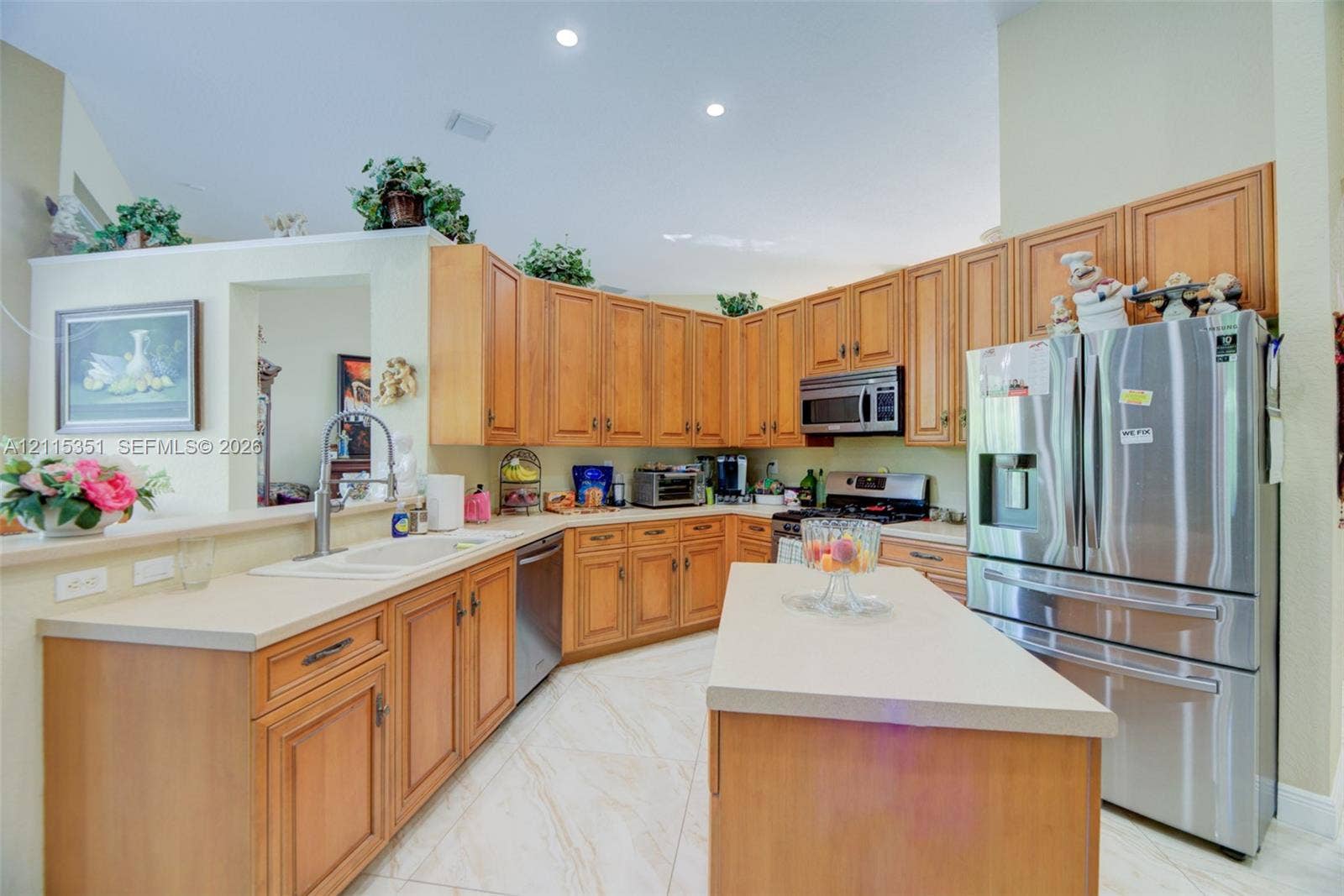 13845 NW 20th Street, Pembroke Pines, FL 33028 Kitchen featuring wood cabinetry, stone-finish countertops, stainless steel refrigerator, center island, and tile flooring