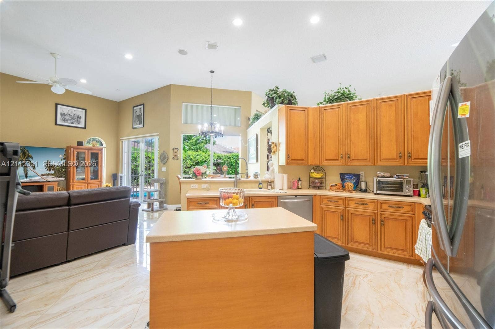 13845 NW 20th Street, Pembroke Pines, FL 33028 Open-concept kitchen featuring stained wood cabinetry, central island with countertop, recessed lighting, and tile flooring
