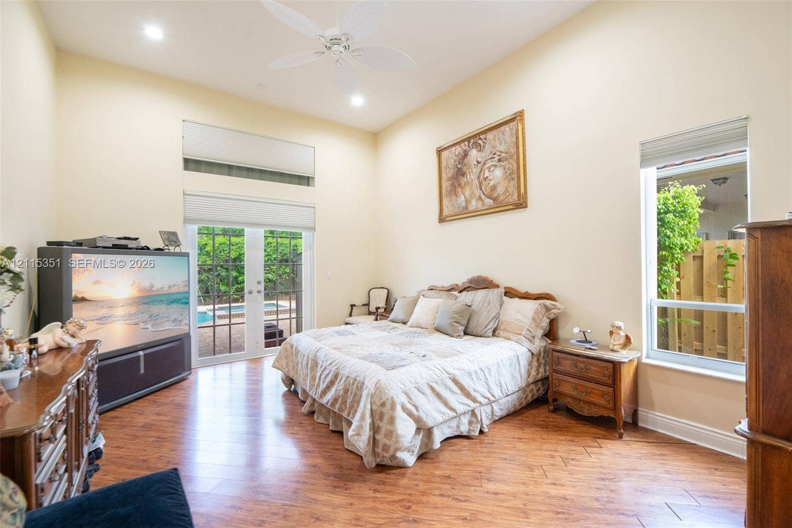 13845 NW 20th Street, Pembroke Pines, FL 33028 High-volume ceiling with recessed lighting and a central ceiling fan, wood-finish flooring in a herringbone pattern, tall transom windows, and full-glass paneled doors