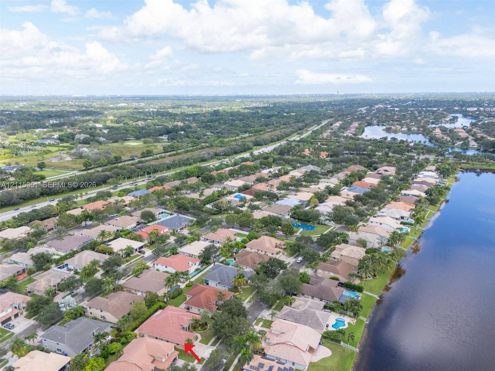 13845 NW 20th Street, Pembroke Pines, FL 33028 Aerial perspective featuring a single-family residence with a multi-hipped roof, situated within a master-planned community featuring multiple ponds and dense landscaping