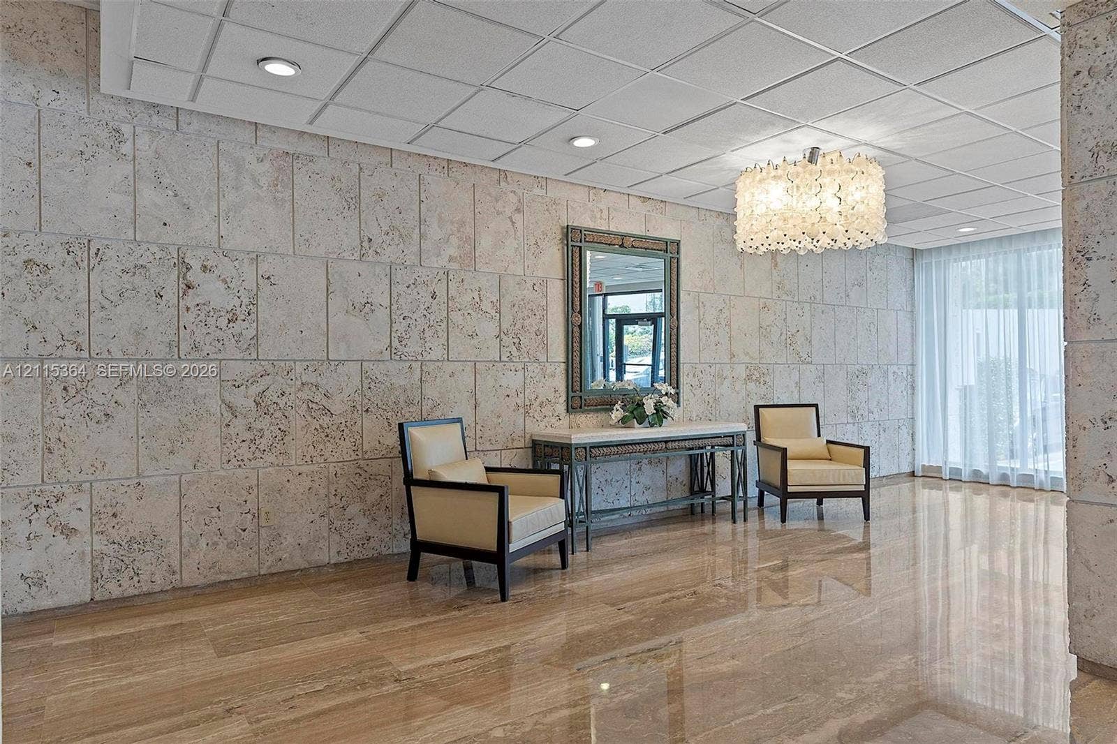 1980 S Ocean Drive, #20A, Hallandale Beach, Hallandale Beach, FL 33009 Polished stone flooring, textured stone wall cladding, recessed ceiling lighting, and a decorative chandelier