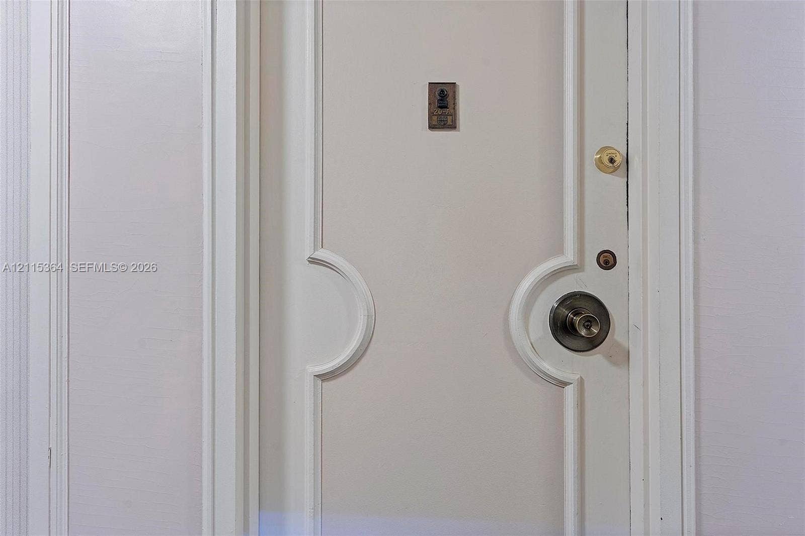 1980 S Ocean Drive, #20A, Hallandale Beach, Hallandale Beach, FL 33009 White interior door featuring recessed arched paneling, brushed metallic hardware, a deadbolt, and an integrated door viewer