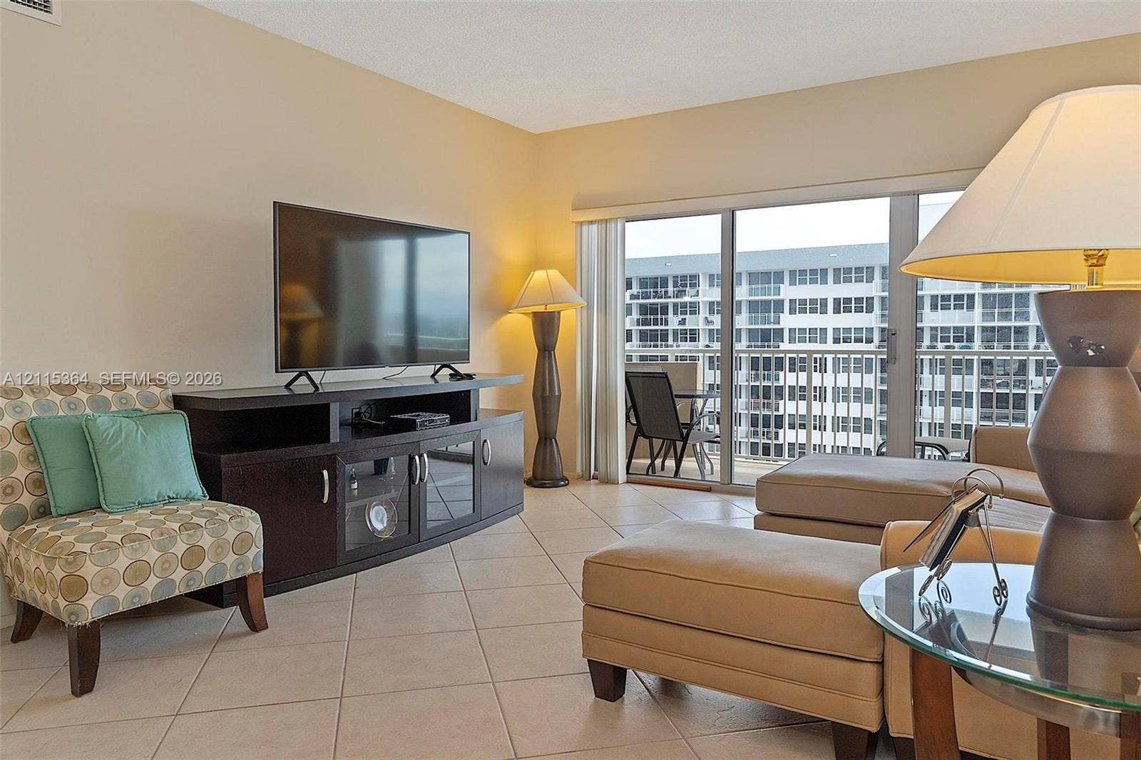 1980 S Ocean Drive, #20A, Hallandale Beach, Hallandale Beach, FL 33009 Neutral-toned interior featuring large-format ceramic tile flooring and floor-to-ceiling sliding glass doors opening to a private balcony