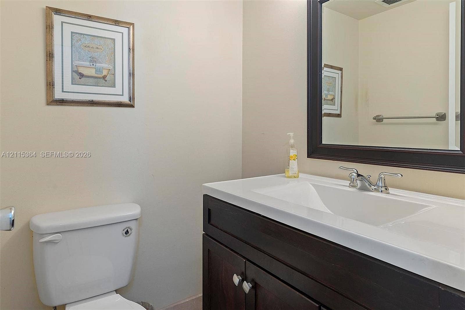 1980 S Ocean Drive, #20A, Hallandale Beach, Hallandale Beach, FL 33009 Dark-finish vanity cabinetry with an integrated white sink, polished chrome faucet, and rectangular framed mirror