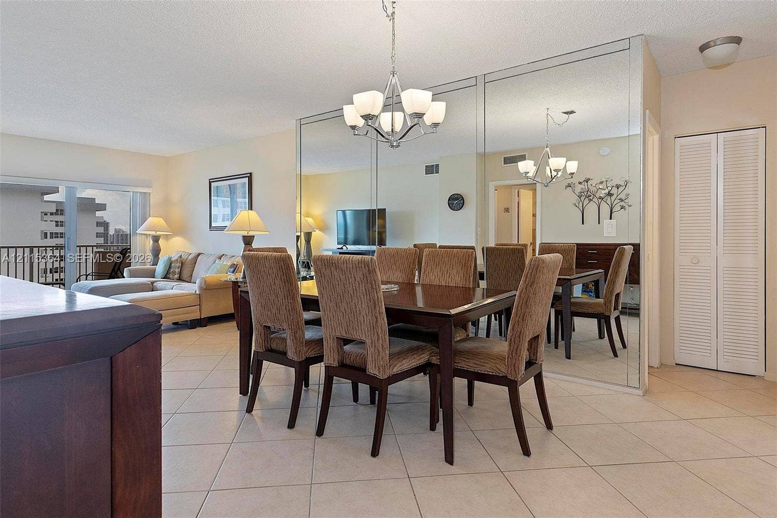 1980 S Ocean Drive, #20A, Hallandale Beach, Hallandale Beach, FL 33009 Dining area featuring tile flooring, floor-to-ceiling wall mirrors, a multi-arm chandelier, and white louvered closet doors