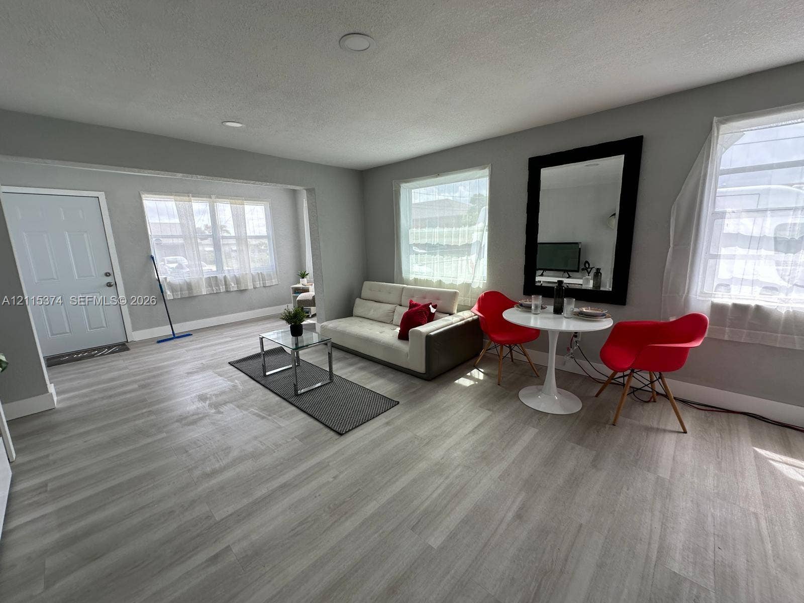 Neutral-toned wood-finish flooring, recessed lighting, and large windows with natural light exposure